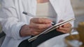 Senior woman hands writing in notebook outdoors close up. Old lady holding pen Royalty Free Stock Photo