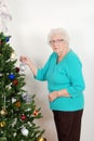 Senior woman hanging christmas ornament Royalty Free Stock Photo