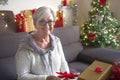 Senior woman happy receives a new tablet as a Christmas present. One elderly modern people tech and social enjoying Christmas