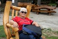 A senior woman having a break in wooden resting chair