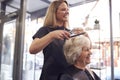 Senior Woman Having Hair Cut By Female Stylist In Hairdressing Salon Royalty Free Stock Photo