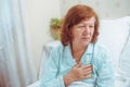 Senior woman having heart attack at home