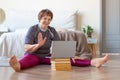 Senior woman having online meeting with a trainer online before a Pilates workout. Royalty Free Stock Photo