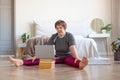 Senior woman having online video call with a coach before pilates workout at home.