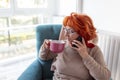 Senior woman having phone conversation and drinking tea Royalty Free Stock Photo