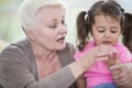 Senior woman helping granddaughter in counting fingers at home Royalty Free Stock Photo