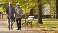 Senior woman helping her disabled blind husband in sunglasses to walk through the park Royalty Free Stock Photo