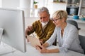 Senior woman helping senior man to use computer Royalty Free Stock Photo