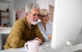 Senior woman helping senior man to use computer Royalty Free Stock Photo