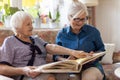 Senior woman and her adult daughter looking at photo album together Royalty Free Stock Photo