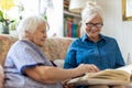 Senior woman and her adult daughter looking at photo album together Royalty Free Stock Photo