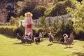 Senior woman in her backyard with free range chickens