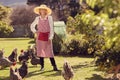 Senior woman with her chickens in backyard