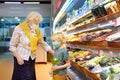 Senior woman and her grandchild wearing disposable medical mask shopping in grocery supermarket during coronavirus pneumonia