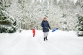 Senior woman and her little grandson shoveling snow off a walkway after massive snowfall. Small child helping outdoors Royalty Free Stock Photo