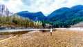 Senior woman on a hike along the Iron Oxide Stained rocks lining the shore of the Squamish River in British Columbia, Canada