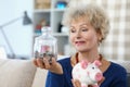 Senior woman hold glass container with saved money for retirement