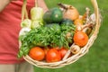 Senior woman holding a basket with vegetables