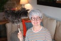 Senior woman holding feather duster Royalty Free Stock Photo