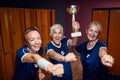 Senior woman holding gold cup feeling joyful about winning fisrt place