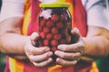 Senior woman holding a jar of cherry compote. Royalty Free Stock Photo