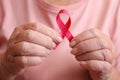 Senior woman holding pink ribbon, closeup. Breast cancer awareness Royalty Free Stock Photo