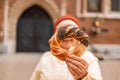 Senior woman holding prezel, traditional polish snack on the Market square in Krakow