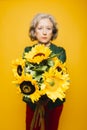 Senior woman holding a sunflower bouquet Royalty Free Stock Photo