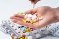 Senior woman holds multicolored different size pills in her hands, hands with manicure.