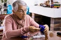 Senior woman at home arranging her prescription drugs into a weekly pill organizer