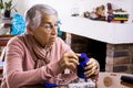 Senior woman at home arranging her prescription drugs into a weekly pill organizer