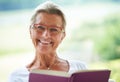 Senior woman, home and book in portrait for reading, relax and living room with smile for story, knowledge or glasses