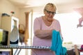 Senior woman at home ironing