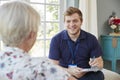 Senior woman at home with male care worker making notes Royalty Free Stock Photo