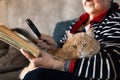 Senior Woman At Home Reading Book Using Magnifying Glass Royalty Free Stock Photo