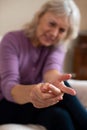 Senior Woman At Home In Pain Suffering With Arthritis