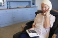 Senior Woman At Home Using Telephone With Over Sized Keys