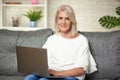 Senior woman at home websurfing on laptop computer