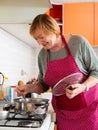 Senior woman housewife in preparing soup at home kitchen Royalty Free Stock Photo