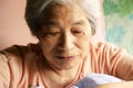 Senior woman innocently playing with a blanket in a nursing bed