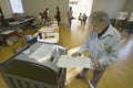 Senior woman inserts completed ballot for Congressional election, November 2006, into an electronic scanner in Ojai, Ventura Count