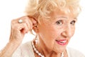 Senior Woman Inserts Hearing Aid Royalty Free Stock Photo