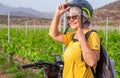 Senior woman inside a vineyard with her electro bike, enjoying outdoors and nature