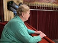 Senior woman is interested in watching ballet performance in theater hall, woman claps and enjoy