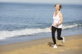 Senior Woman Jogging Along Beach Royalty Free Stock Photo