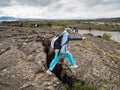 Senior woman is jumping over an earth gap at Thingvellir National Park -Iceland Royalty Free Stock Photo