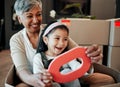 Senior woman, kid and moving boxes with smile, playing and happy with grandmother, grandchild or new property. Family