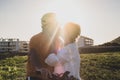 A senior woman kisses her cyclist husband putting on his helmet before riding a bicycle. Bright sunset light Royalty Free Stock Photo