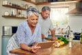 Senior woman at kitchen counter with man, tablet and cooking healthy food together in home. Digital recipe, smile and Royalty Free Stock Photo