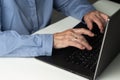 Senior gray-haired woman with laptop. Elderly woman writing memoirs on laptop, searching for information on the Internet or